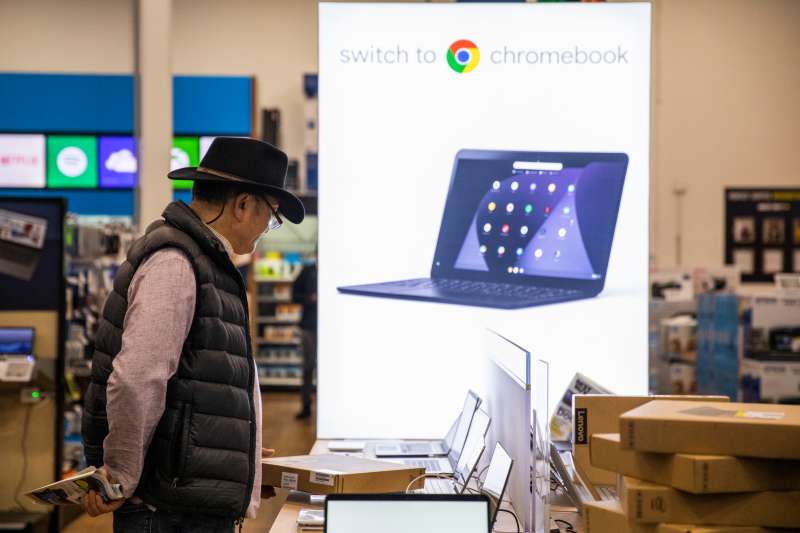 A Black Friday shopper looks at laptop computers at a Best Buy store on November 29, 2019.
