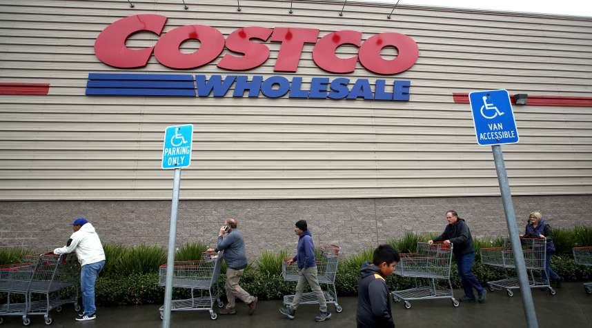 Customers wait in line to enter a Costco store on March 14, 2020 in Novato, California.