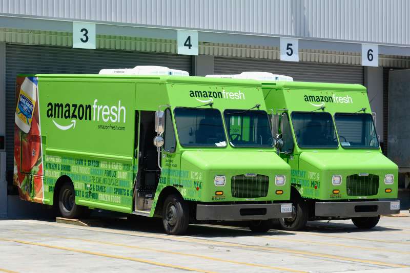 Amazon Fresh trucks sit parked at a warehouse in Inglewood, California.
