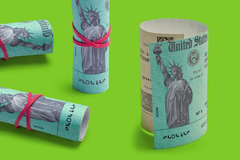 Four rolled up stimulus checks on a colored background