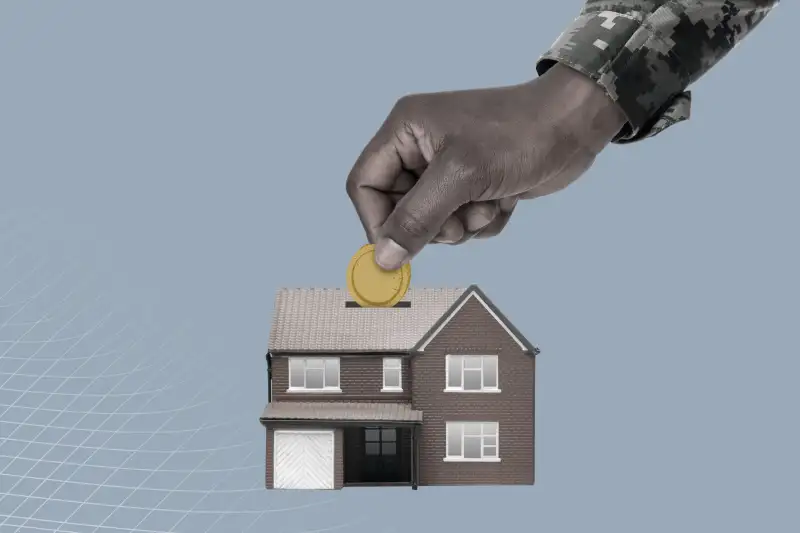 Hand Of An Army Soldier Placing Coin Inside A Small House Shaped Piggy Bank