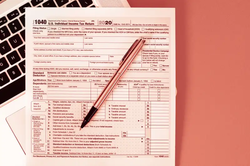 1040 Tax form laying on top of a computer keyboard.