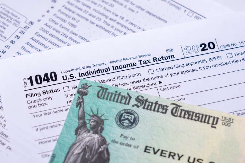 Stimulus Check lying over a 1040 Tax Form
