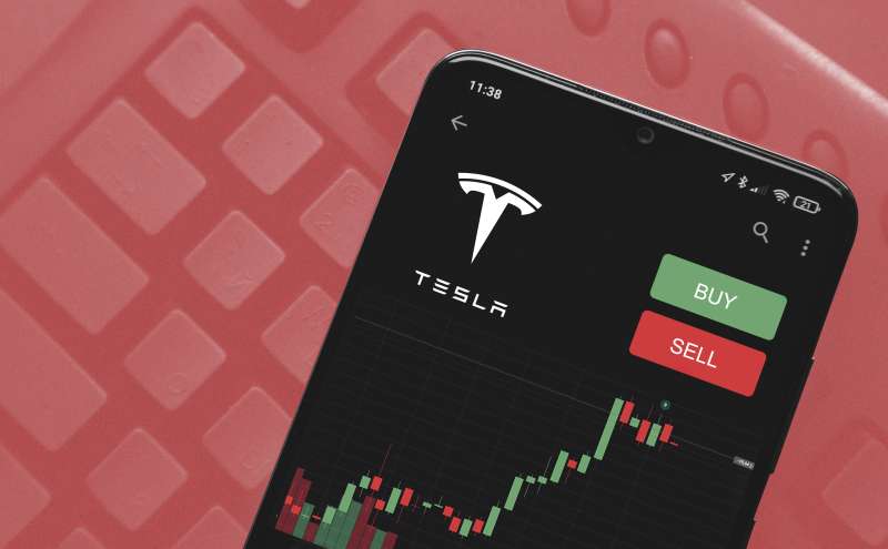 Phone showing Tesla stocks with the option to buy or sell.