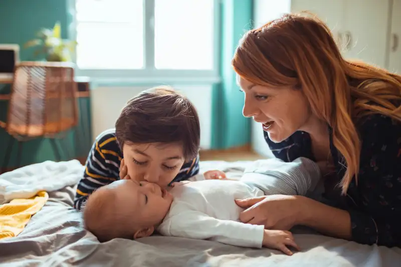 Close up of a mother playing with her kids in the bedroom