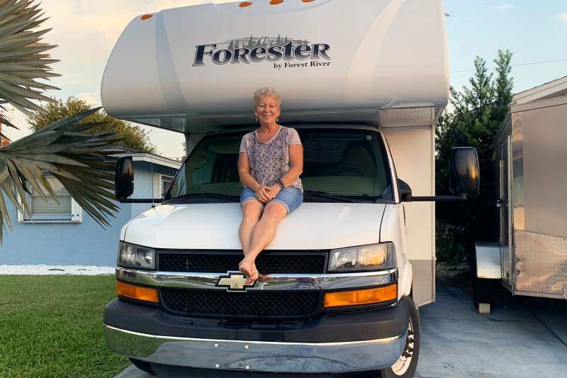 Photograph of Robin Focht sitting on the hood of her RV