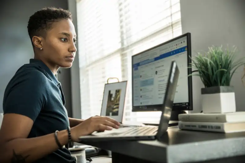 Young woman working on desktop computer at home