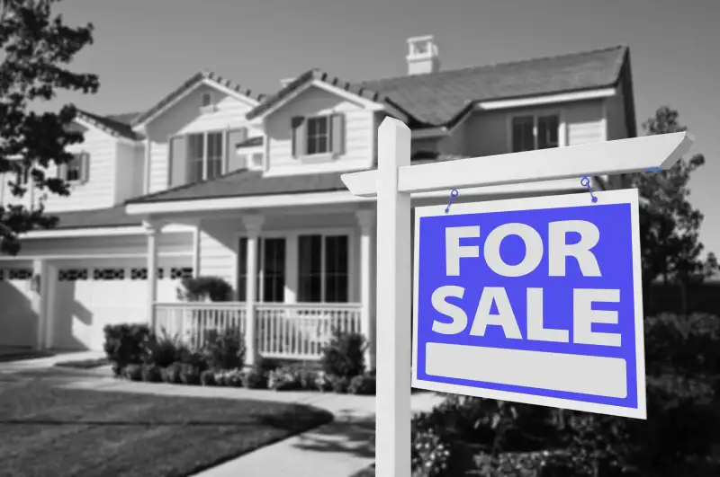 Home with a  For Sale  sign in the front yard