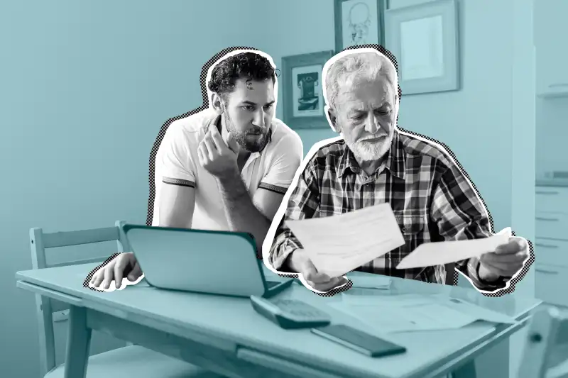 Senior Man looking over life insurance papers with the help of his son.