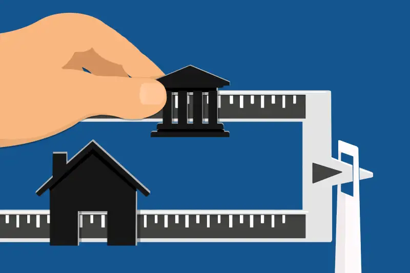 A scale that has the lager measuring part in the shape of a house, and the smaller one in the silhouette of a university building.