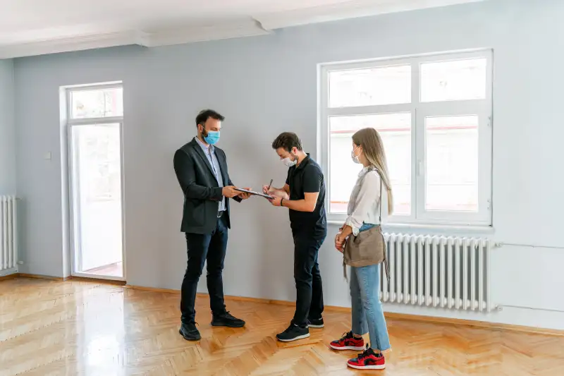 Home Inspector walks through an empty home with a young couple