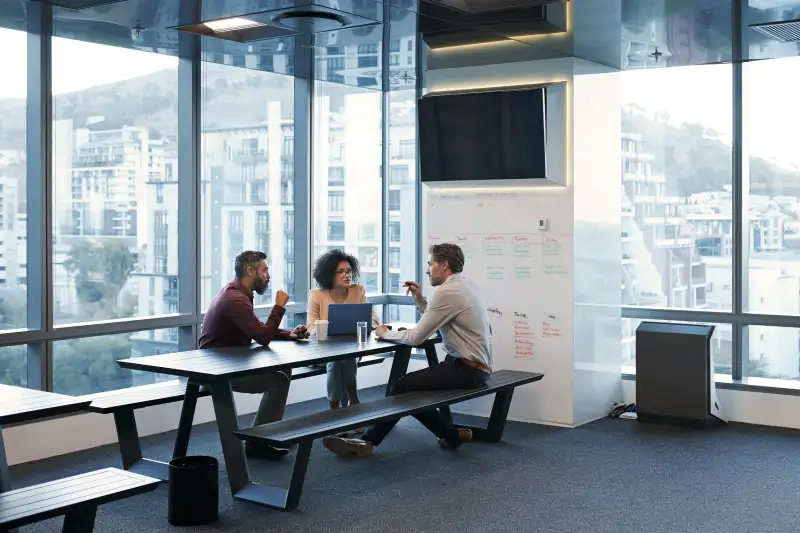 Three employees working together in an office space