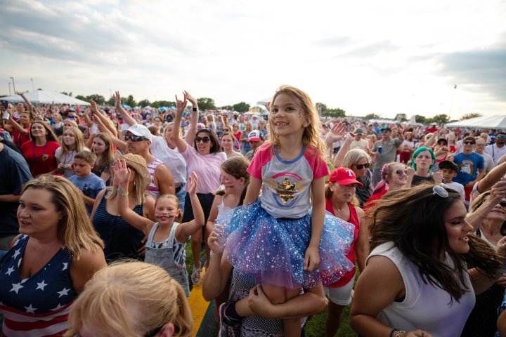A girl in the crowd smiles of camera during a concert performance in Flower Mound Texas