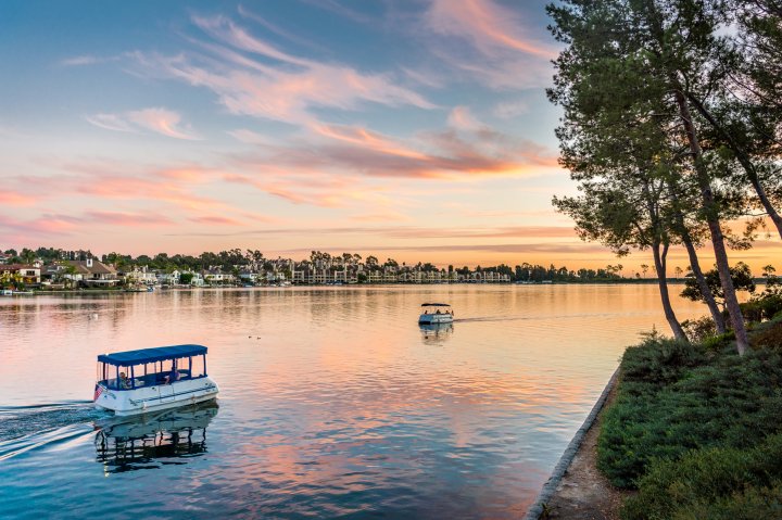 Two small passenger boats travel at sunset in Mission Viejo California
