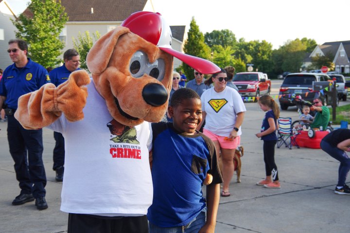 A young boy poses with a person in a dog costume at a city event in St.Peters Missouri