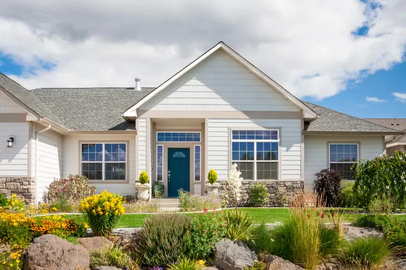 New home with gorgeous rock garden on a sunny day