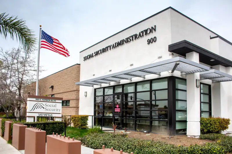 A local Social Security Administration building with an American flag at the entrance