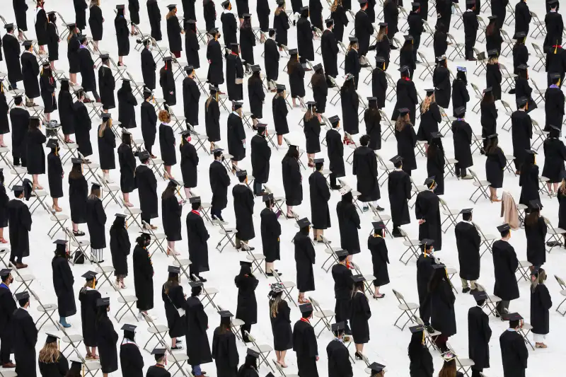 Students are spaced apart during a graduation ceremony at Fenway Park