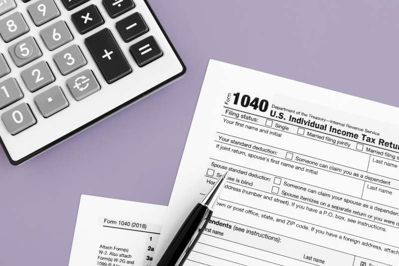 Close up of a 1040 Tax Return form, a pen and a calculator