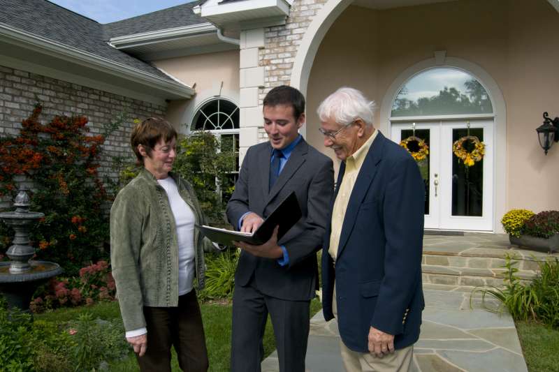 Real estate agent showing a new home to a senior couple