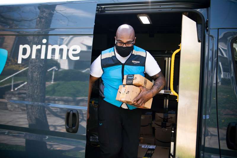 Amazon driver carrying packages out of a Prime truck