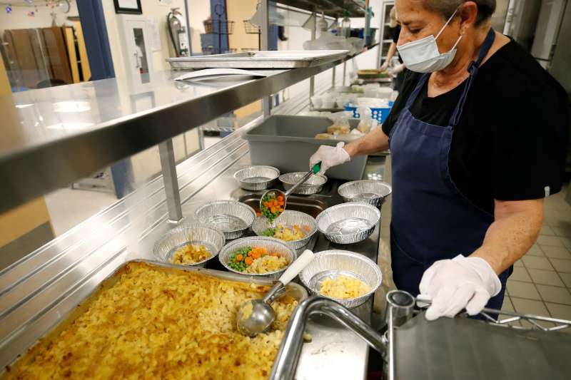Cafeteria worker prepares individual plates for students