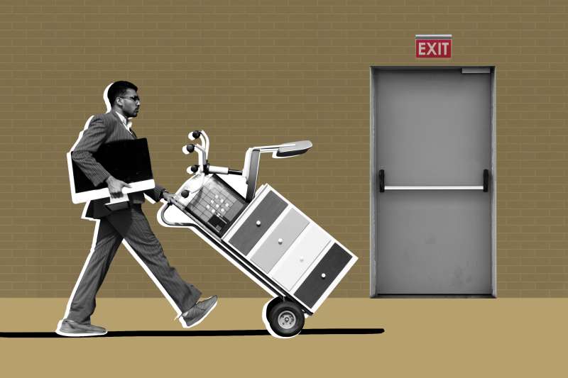 Man carrying his computer and office files and walking towards an Exit Door