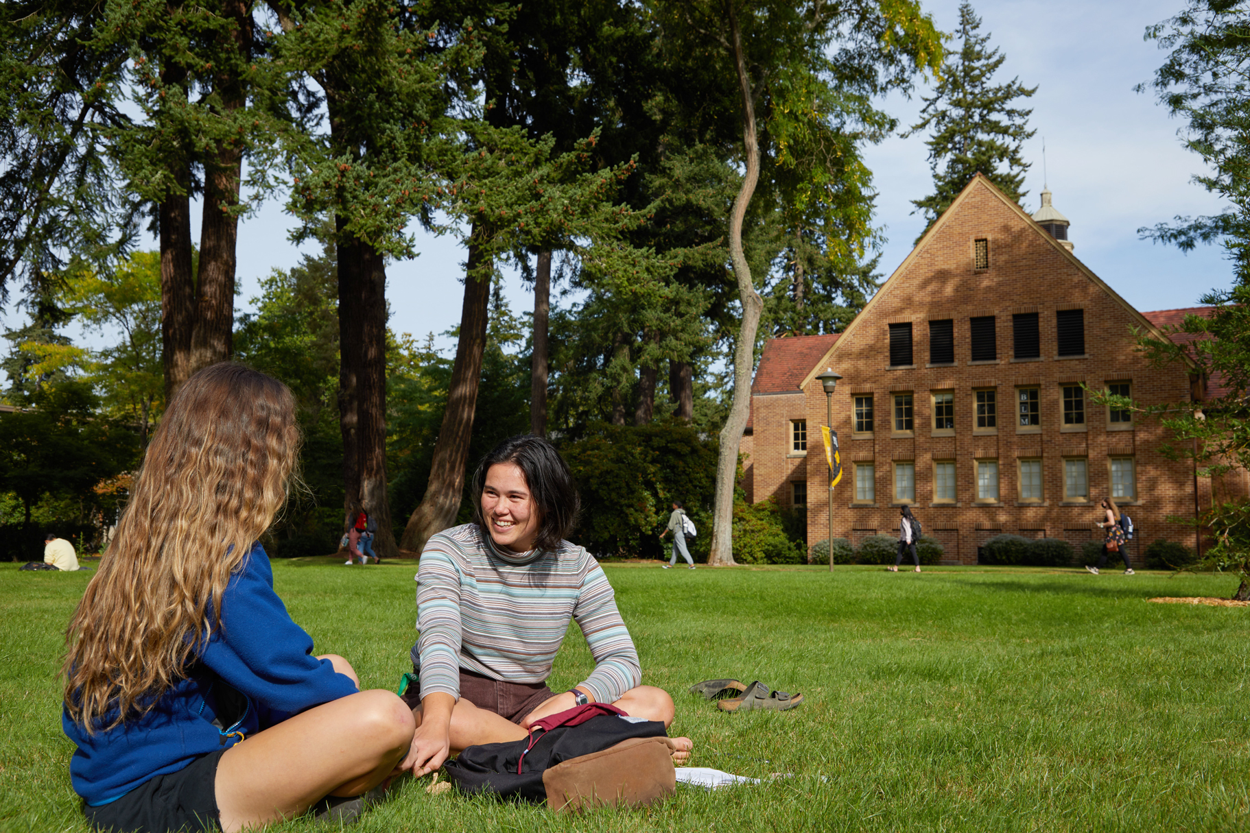Two students sit in the lawn at Pacific Lutheran University