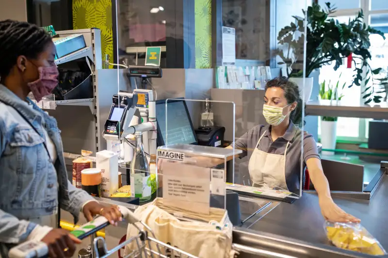 Woman at grocery store scanning products at the checkout counter