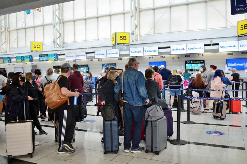 People wait in line to receive information on their flights after Southwest Airlines continued to cancel and delay a handful of flights
