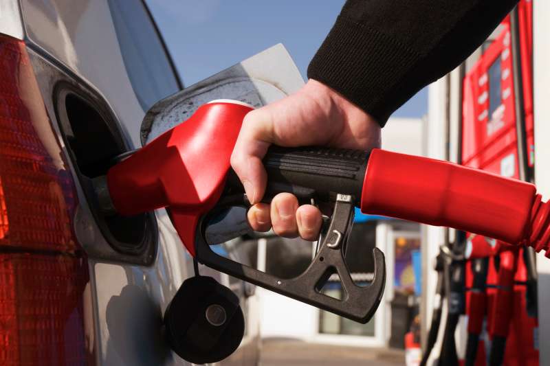 Photo close up of a person pumping gas into car
