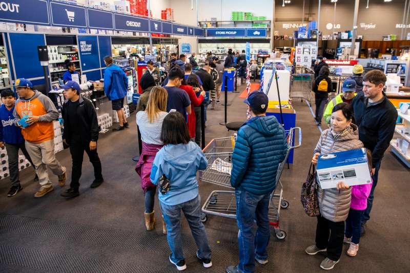People form a queue line inside a Best Buy store