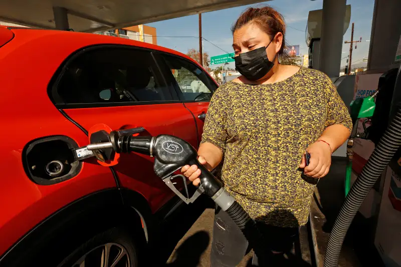 Woman puts fuel in her car's gas tank