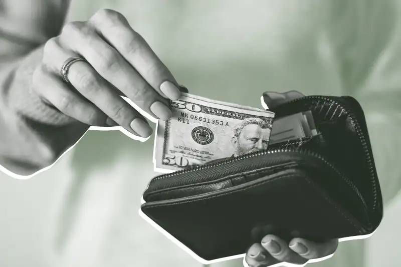 Close up of a hand taking out a fifty dollar bill from their wallet