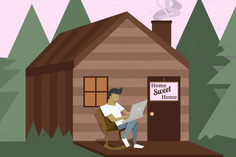 Man Using Laptop While Sitting On A Rocking Chair On The Porch Of A Cabin In The Woods