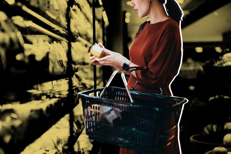 Woman inspecting a product while she is shopping at a supermarket