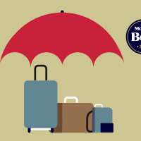 Three suitcases under a large umbrella