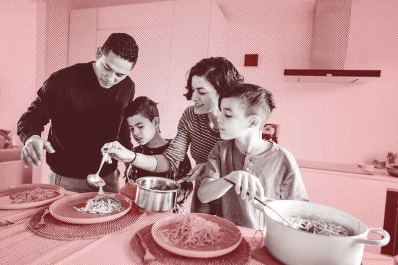 Family of four serving pasta on their plates