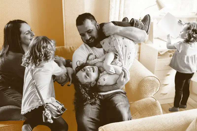 Happy young family of five laughing and playing together in home