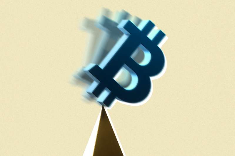 A Bitcoin sign is falling off a balancing pyramid's edge