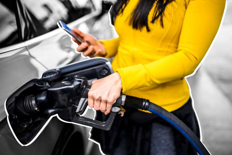 Close-up of a woman refueling her car at a gas station