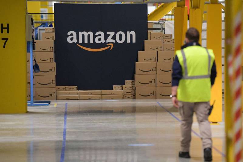 Amazon Employee Walking In Warehouse Filled With Boxes