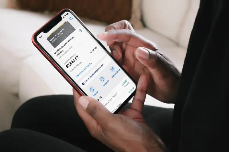 Close-up of a smartphone reviewing their American Express Rewards Checking account