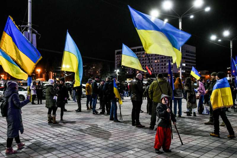People hold Ukrainian flags during the Zaporizhzhia Will Resist viche in Maidan Heroiv on the Day of Unity