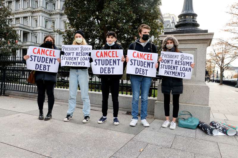 A group of protestors hold signs demanding student loan relief
