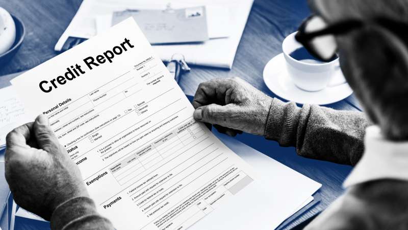 Close-up of a man holding up a credit report application
