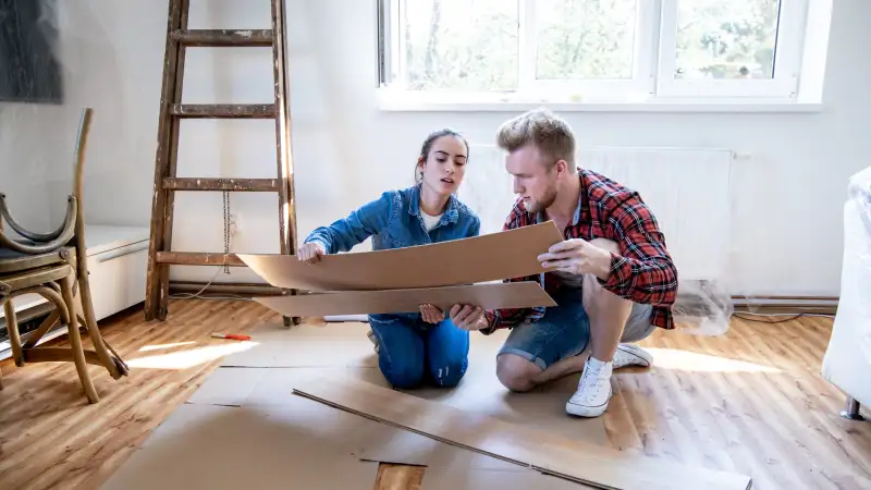 A couple looking at laminate wood flooring in their living room