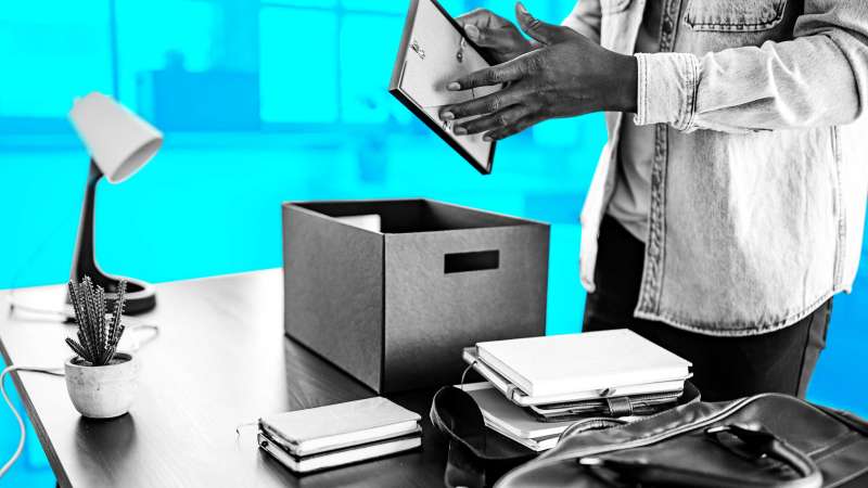 Person In Office Placing Desk Items In Box