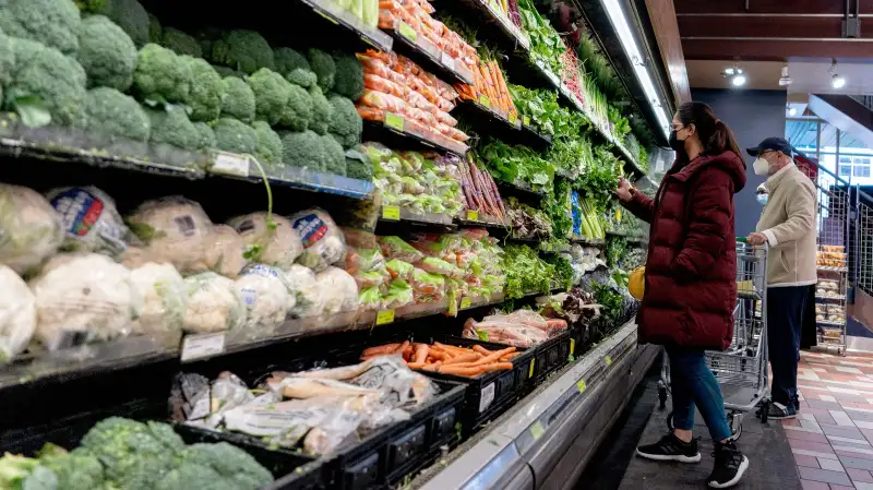 People at a grocery stores picking vegetables