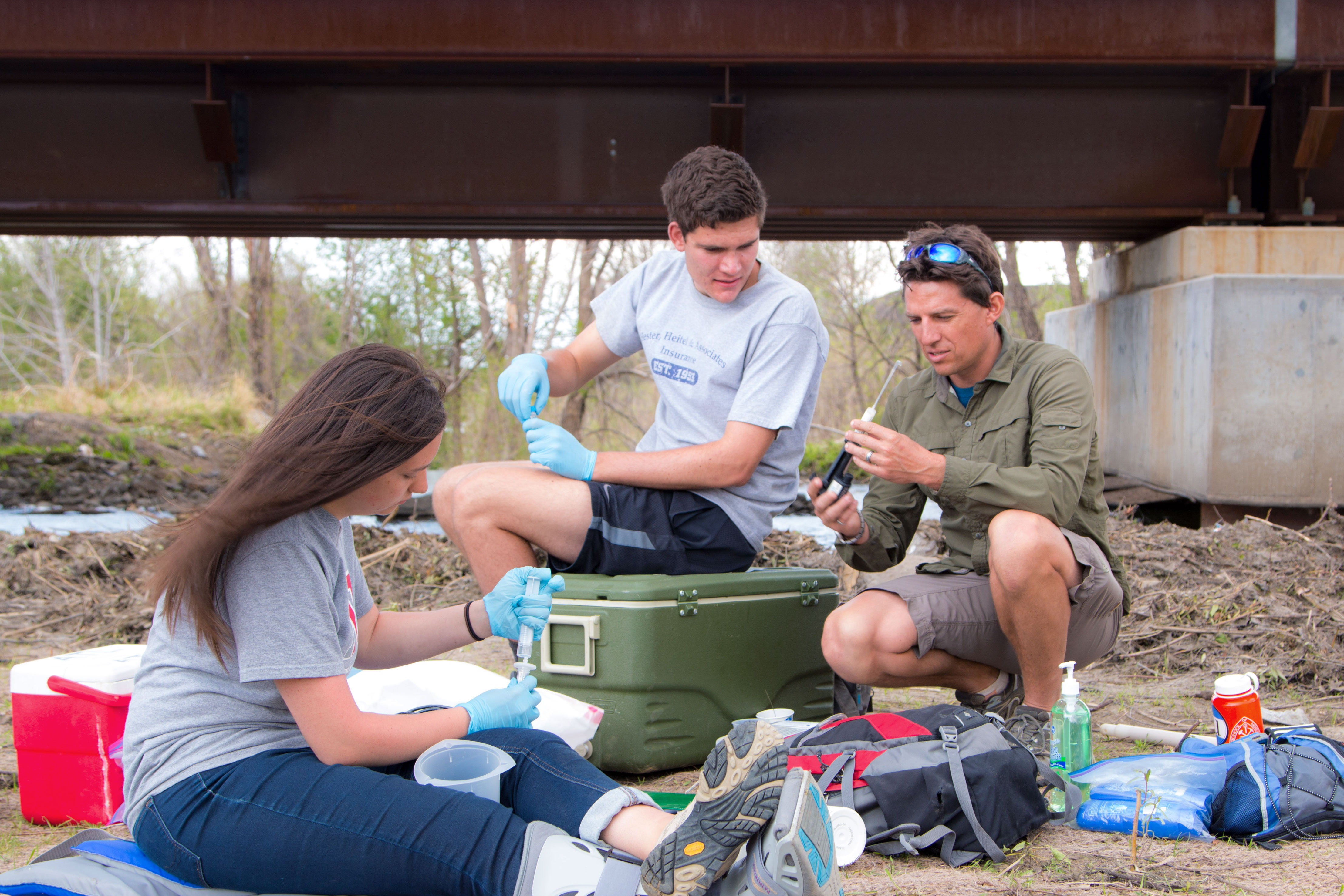 Student and a Teacher examine a dirt sample at a class conducted outside for the Colorado School of Mines